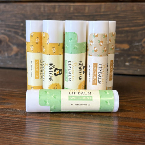 Group of different beeswax lip balms on wooden surface