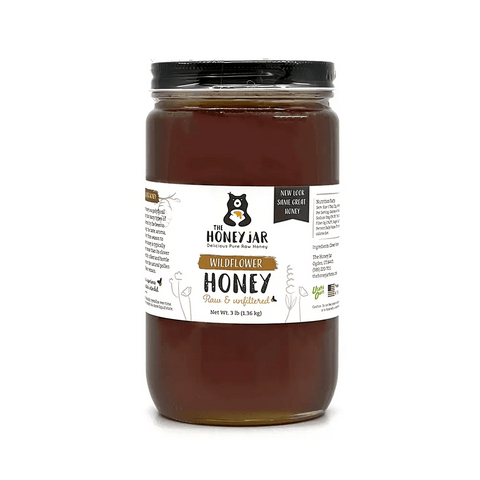 Jar of wildflower honey on white background