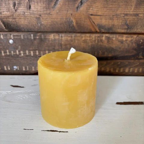 Yellow candle on a wooden surface