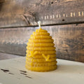 Beeswax candle shaped like a beehive on a wooden surface