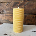 Beeswax candle with honeycomb pattern on a wooden surface