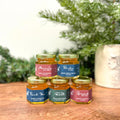 Jars of honey with labels on a wooden surface with a blurred natural background