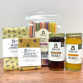 Honey sticks, jars of honey, and beeswax food wrap on a wooden surface.