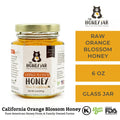 Jar of raw orange blossom honey with 'The Honey Jar' branding on a white background