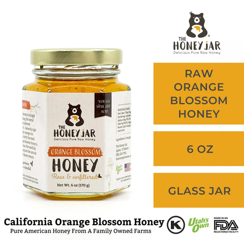 Jar of raw orange blossom honey with 'The Honey Jar' branding on a white background