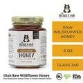Jar of raw wildflower honey with 'The Honey Jar' branding on a white background