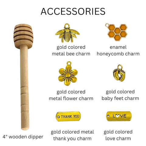 Collection of gold-colored accessories including a wooden dipper, bee, honeycomb, flower, baby feet, thank you, and love charms on a white background.