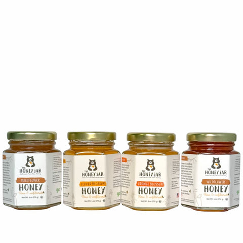 Four jars of Honey Jar honey on a white background