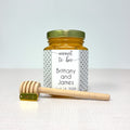 Honey jar with personalized label and honey dipper on a white background
