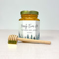 Honey jar with personalized label and honey dipper on a white background