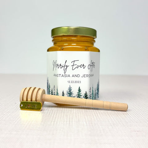 Honey jar with personalized label and honey dipper on a white background