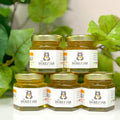 Jars of honey from The Honey Jar with a green leafy background