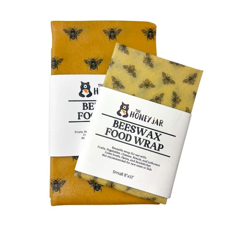 Two pieces of beeswax food wrap with bee designs on a white background