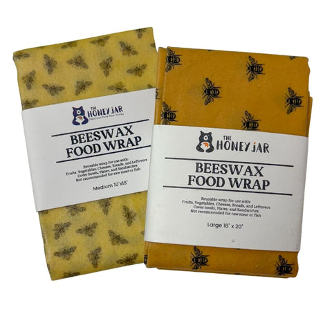 Two packages of 'The Honey Jar' beeswax food wrap with bee designs on a white background.