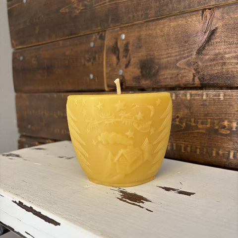 Yellow textured candle on a rustic wooden surface with a wooden panel background