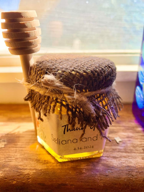 Jar of honey with a wooden dipper on a wooden surface