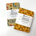 Two packages of Beeswax Food Wrap with floral designs on a white background