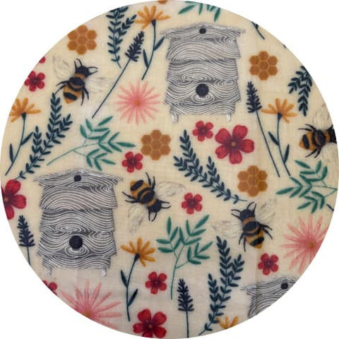 Round fabric sample with bee and flower pattern on a white background