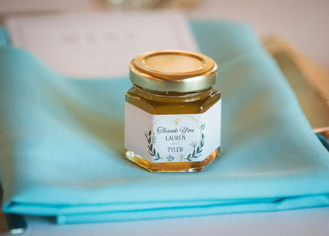 Jar of honey with a label on a blue fabric background