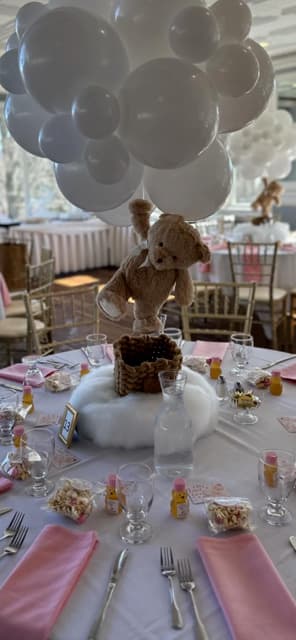 Decorative table setting with teddy bear centerpieces and pink napkins.