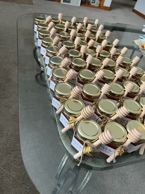 Jars of honey with dipper sticks on a glass table