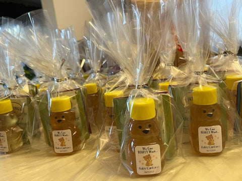 Bear-shaped honey bottles in clear packaging on a wooden surface