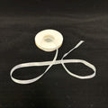 Spool of white ribbon on a black background