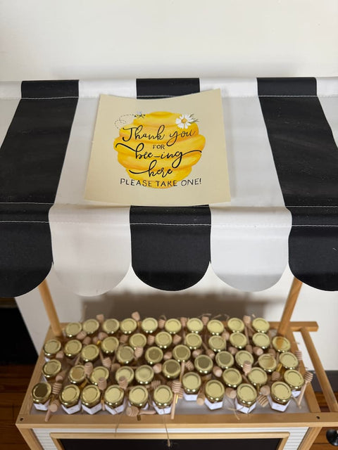 Table with gold jars and a sign on a black and white checkered tablecloth