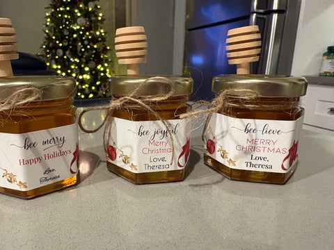 Three jars of honey with personalized labels on a kitchen counter.