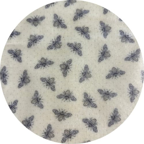 Round fabric swatch with bee pattern on a beige background