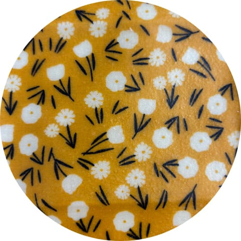 Round fabric swatch with white flowers on a yellow background
