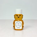 Honey bear with Happy Holidays label and white lid on white surface