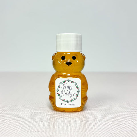 Honey bear with Happy Holidays label and white lid on white surface