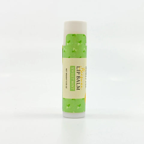Lip balm with green and white packaging on a white background