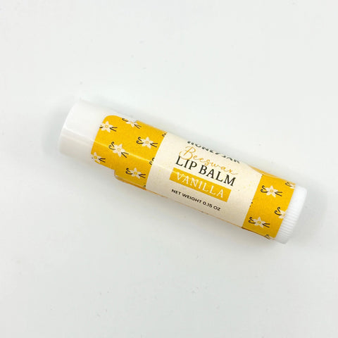 Vanilla lip balm with yellow and white packaging on a white background