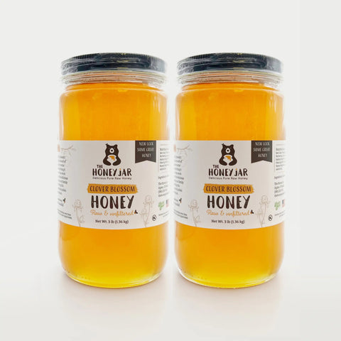 Two jars of clover blossom honey from The Honey Jar on a white background