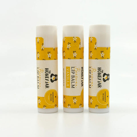 Three lip balms with yellow and white packaging on a white background