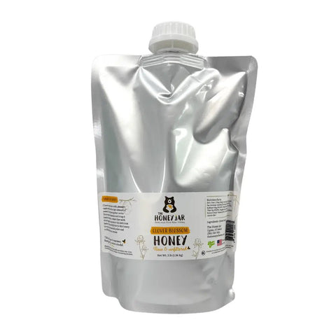 Mylar bag filled with honey with a white cap on a white background