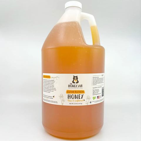 Gallon jug of honey with a label on a white background