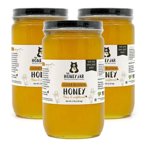 Three jars of honey with labels on a white background