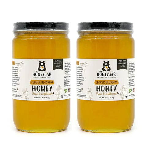 Two jars of 'Clover Blossom Honey' from 'The Honey Jar' on a white background