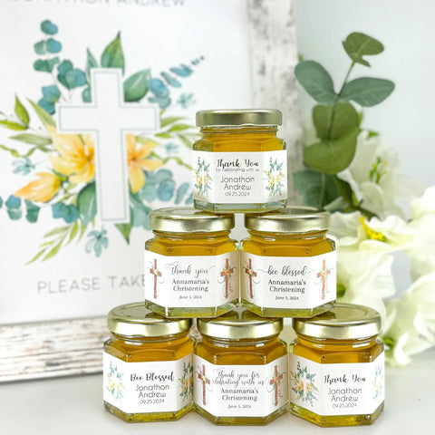 Jars of honey with personalized labels on a decorative background with flowers and a cross.