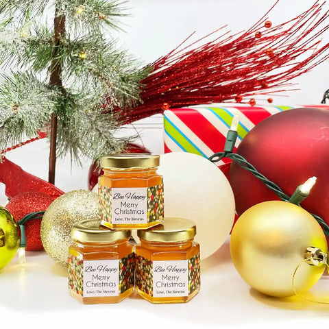 Three jars of Bee Happy honey with Christmas decorations in the background