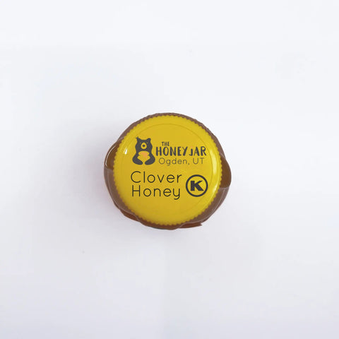 Honey jar lid with 'The Honey Jar Ogden, UT' and 'Clover Honey' text with kosher symbol on a white background