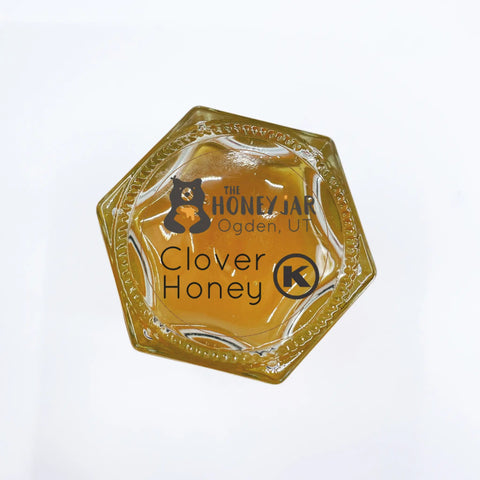 Hexagonal honey container with 'The Honey Jar' branding and kosher label on a white background