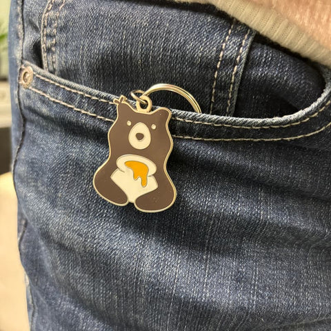Bear-shaped keychain attached to a person's jeans pocket