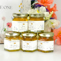 Five jars of honey with personalized labels on a floral background