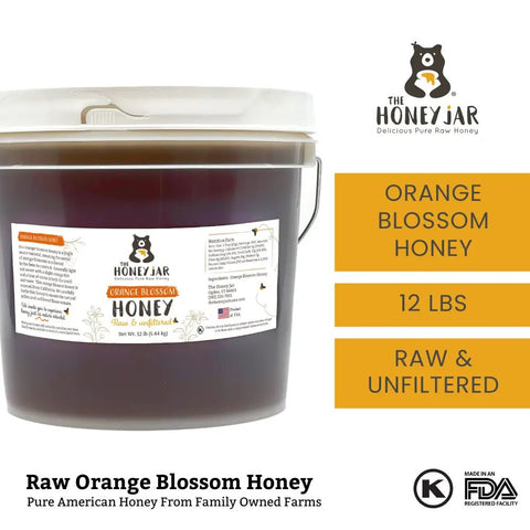 Bucket of raw orange blossom honey with The Honey Jar branding on a white background