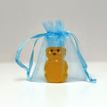Honey bear in a blue organza bag on a light gray background