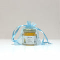 Jar of honey in a transparent blue bag on a light gray background